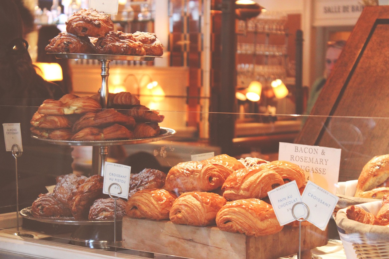 Bakery display counter piled with croissants, pains au chocolat and Danish pastries