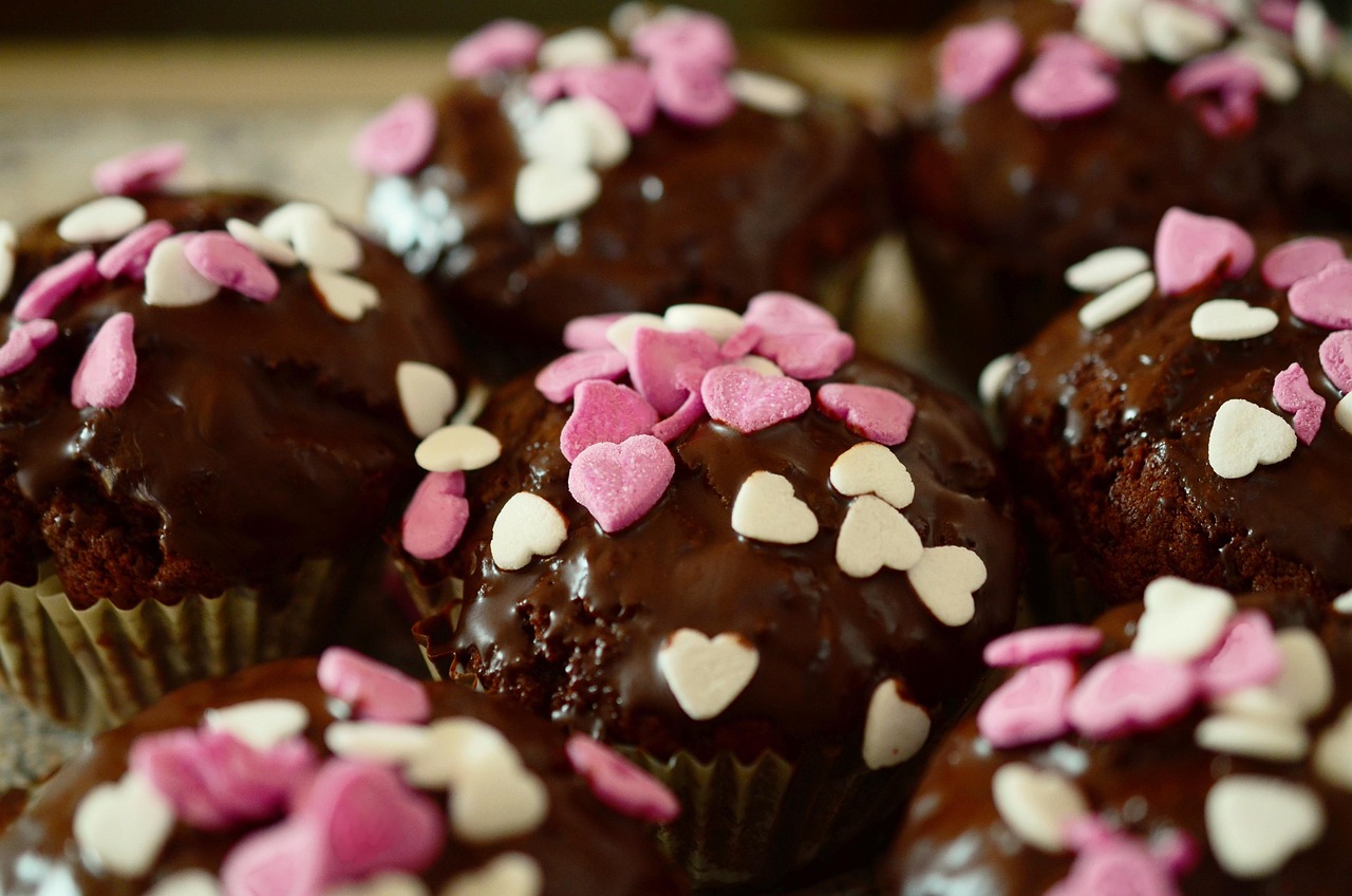 Chocolate cupcakes scattered with pink and white heart sprinkles